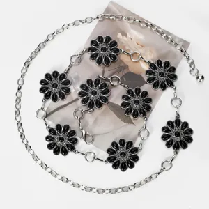 Chaîne de taille en métal argenté avec breloques florales noires, détail pour style bohème.