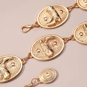 Chic ceinture chaîne métal doré avec motifs de bottes western ovales pour femmes élégantes.