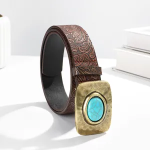 Gros plan sur la ceinture en cuir gaufré style occidental avec une grande boucle en turquoise.