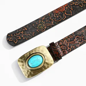 Gros plan sur la ceinture en cuir gaufré vintage avec une boucle turquoise et bronze.
