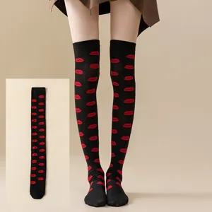 Nahaufnahme von schwarzen Overknee-Socken mit durchgehendem roten Lippen-Druckmuster.