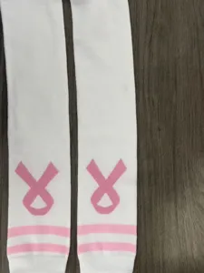 Nahaufnahme von weißen Damen-Kniestrümpfen mit pinken Streifen und Schleifenmuster.