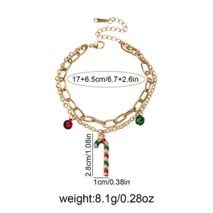 Vista dettagliata del bracciale a catena d'oro con bastoncino di zucchero natalizio e campanelli.