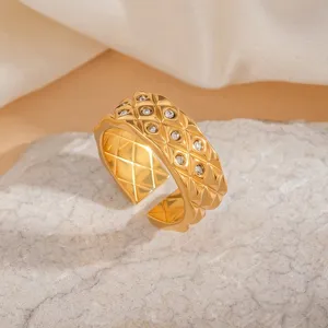 Détail de la bague dorée en acier inoxydable matelassé avec des zircons brillants et élégants.