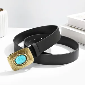 Gros plan détaillé de la ceinture en cuir noir vintage avec boucle en laiton et pierre turquoise.