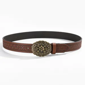 Vista detallada del cinturon de cuero marron repujado con hebilla floral de bronce.