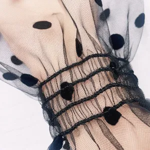 Detailaufnahme von schwarzen Mesh Sonnenschutz Ärmeln mit süßen Beflockungs Punkten.