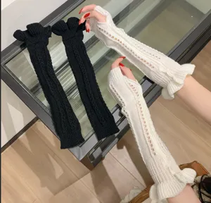 Close-up detail of breathable knitted arm warmers featuring delicate hollow design and ruffles.