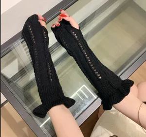 Black knitted long arm warmers detail shot, featuring hollow-out lace and ruffle cuffs.