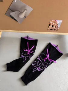 Black knit leg warmers with purple bow and skull design, stylish gothic JK warmers.