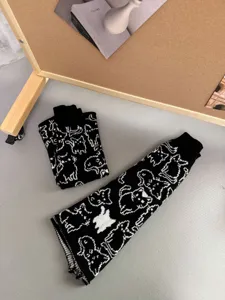 Knit cat pattern leg warmers, cute black and white stackable socks for winter warmth.