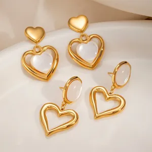 Detail view of French style hollow cat's eye heart stainless steel earrings in gold finish.
