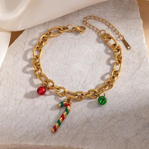 Close-up of gold stainless steel Christmas charm bracelet with cute candy cane and bell pendants.