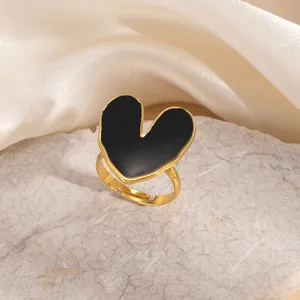 Anello in acciaio inossidabile dorato con dettaglio cuore smaltato nero, elegante.