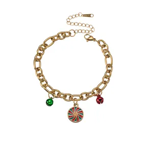 Close-up detail view of Christmas candy charm and bells on gold chain bracelet.