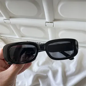 Detailansicht trendiger schwarzer Retro-Rechteck-Sonnenbrille im minimalistischen Stil.
