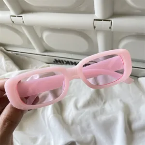 Rosa rechteckige Sonnenbrille mit Retro-Gelly-Farbe, dickem Rahmen und trendy Streetwear-Detailansicht.