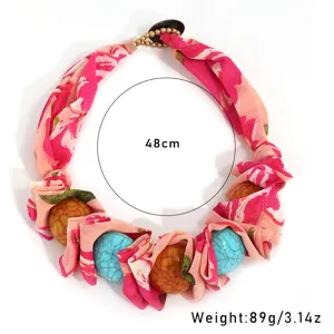 Detail view of colorful print fabric and turquoise bead necklace with 48cm length measurement