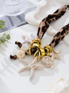 Vista detallada del collar bohemio de leopardo con dijes de estrella de mar y caracol