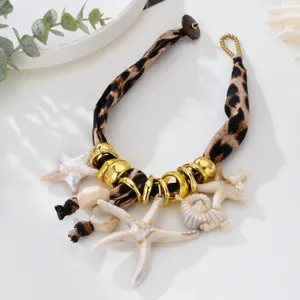 Vista detallada de collar bohemio de leopardo con dijes de estrella de mar y concha.