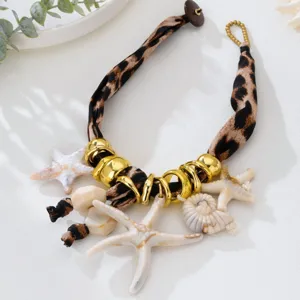 Detalle del collar de leopardo con estrellas de mar de resina y colgantes de concha.