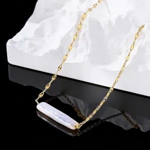 Close-up of minimalist gold chain necklace with a white bar pearl pendant details