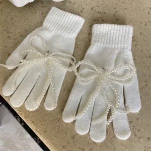 Weiße Strickhandschuhe mit elegantem Perlen-Schleifen-Design, warme süße Winteraccessoires.
