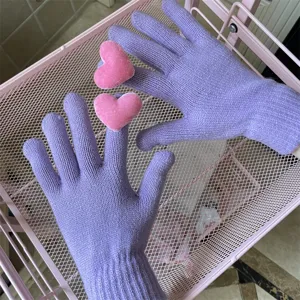 Nahaufnahme von weichen Lavendel-Lila Strickhandschuhen mit niedlichen rosa Herz-Details.