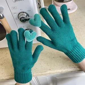 Grüne Strick-Touchscreen-Hände mit süßen Plüschherzen, warm und gemütlich für den Winter.