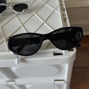 Schicke schwarze Cat-Eye Sonnenbrille mit Perlenanhänger, modische Brille für Damen und Herren.