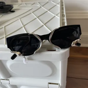 Schwarze Cat-Eye-Sonnenbrille mit silbernem Metalldekor und Perlenanhänger Modetrend