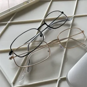 Nahaufnahme von zwei stilvollen Metallbrillengestellen in Schwarz und Gold, modernes Accessoire.