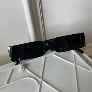 Nahaufnahme Detail von trendigen schwarzen schmalen Sonnenbrillen mit Perlenanhänger.