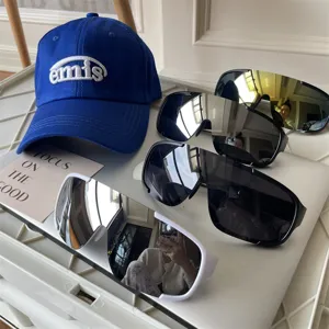 Grosse futuristische Sportsonnenbrille und modische bestickte Baseballkappe fuer Outdoor.
