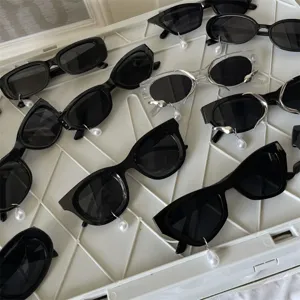 Detailansicht von modischen Sonnenbrillen mit Perlenanhängern, trendiges Brillen-Design.