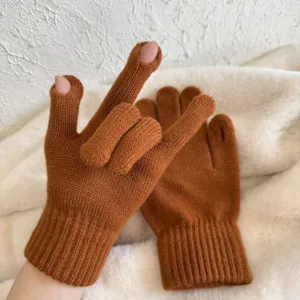Detailaufnahme karamellbrauner Strickhandschuhe mit Fingeröffnung und weicher Woller Textur.