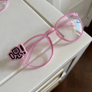 Rosa Y2k Stil Brillenrahmen Detailansicht mit einem süßen dekorativen Anhänger.