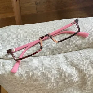 Detail shot of Y2K cyberpunk upside-down glasses frame, stylish metal and pink design.