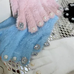 Detailaufnahme süßer Plüsch-Winterhandschuhe, verziert mit funkelnden Strasssteinen und Perlen.