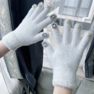 Detailansicht der weissen flauschigen Winterhandschuhe mit eleganten Perlen und Strasssteinen.