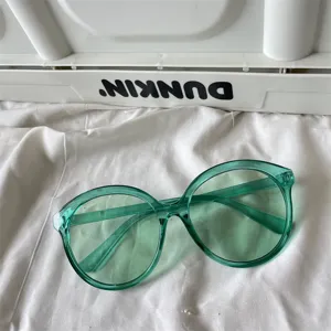 Transparente grüne ronde zonnebril in snoepkleur dopamine stijl voor trendy dames modeoutfit.