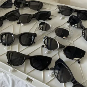 Modische Katzenauge Sonnenbrille mit Perlenanhänger, stilvolle schwarze Brille.