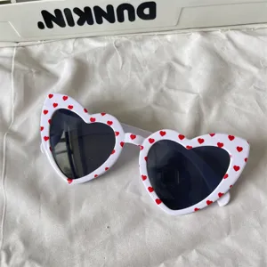 Herzförmige Sonnenbrille mit süßen roten Herzen auf weißem Gestell für Sommer und Alltag.