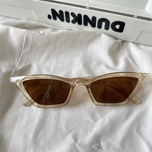 Modische schmale Katzenaugen Sonnenbrille mit transparentem Teebraunem Rahmen und braunen Gläsern.