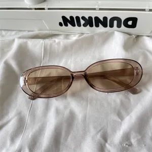 Braune ovale Sonnenbrille Detailaufnahme, trendiger transparenter Rahmen für Streetstyle.