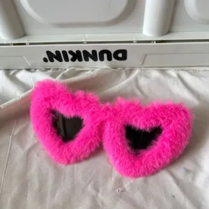 Detailansicht der knalligen rosa flauschigen Herz Sonnenbrille, trendiges Accessoire.