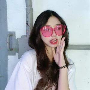 Detailaufnahme von stylischer übergroßer rosa Sonnenbrille am Model, trendiges süßes Street-Accessoire.