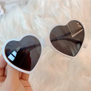 Nahaufnahme trendiger weißer Herz Sonnenbrillen mit dunklen Gläsern für süßen Retro Look.