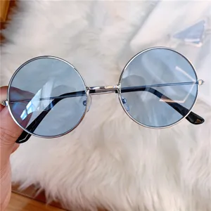 Retro runde Sonnenbrille mit rauchblauen Glaesern und silbernem Metallrahmen, Detail.