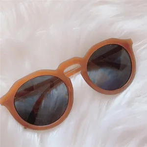 Retro runde Sonnenbrille Detailaufnahme, karamellbrauner Rahmen mit dunklen Gläsern, Chic.